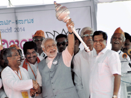 BJP Prime Ministerial candidate Narendra Modi holds a mace at an election rally at Bagalkot in north Karnataka on Tuesday. PTI Photo