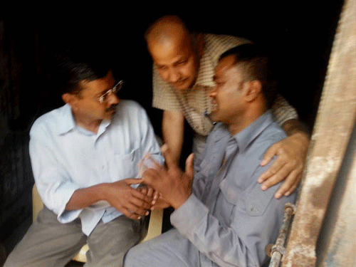 AAP convener Arvind Kejriwal with party leader Manish Sisodia meeting Lali, the autorickshaw driver who attacked him during his road show, in New Delhi on Wednesday. PTI Photo