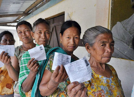 Women voters show their i-cards as they stand in a queue to cast their votes for Lok Sabha elections at Pasighat in East Siang district in Arunachal Pradesh on Wednesday. PTI Photo