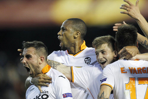 Valencia's Paco Alcacer, left, celebrates scoring against Basel with teammates Seydou Keita, center, and Fede Cantabria, right, during the Europa League quarterfinal, second leg soccer match at the Mestalla stadium in Valencia, Spain, on Thursday, April 10, 2014. Valencia lost 3-0 in the first leg at Basel.  AP Photo