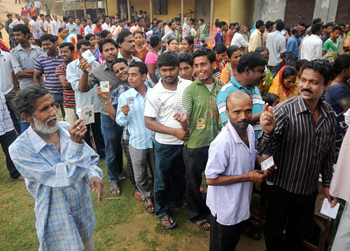 People stand in line to cast their votes during the first phase of elections in Agartala on Monday. PTI Photo