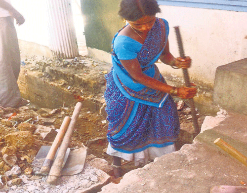 Aworker cleaning a drain barefoot and without gloves in Koramangala. DH photo
