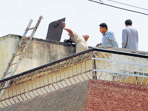 Officials search an overhead tank on the house of  financier Babu Lal in Bellary on Sunday. DH Photo