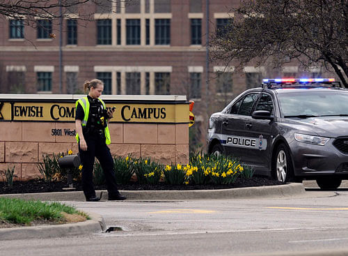 An Overland Park Kansas police officer guards the entrance to the scene of a shooting at the Jewish Community Center of Greater Kansas City in Overland Park, Kansas April 13, 2014. Three people were killed in shootings at Jewish centers in Kansas on Sunday and a suspect was in custody, according to police and local media. The shootings occurred at the Jewish Community Center and at Village Shalom, an assisted living center about a mile away, according to local media. REUTERS