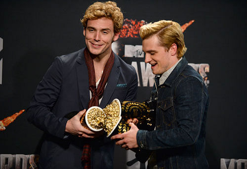 Sam Claflin, left, poses with the award for best movie of the year and Josh Hutcherson poses with the award for best male performance for 'The Hunger Games: Catching Fire' in the press room at the MTV Movie Awards on Sunday, April 13, 2014, at Nokia Theatre in Los Angeles. AP