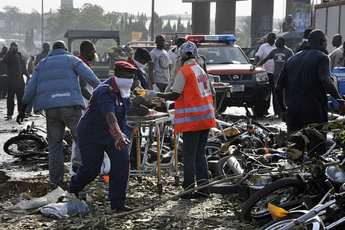 Rescue workers work to recover victims at the site of a blast at the Nyanya Motor Park, about 16 kilometers (10 miles) from the center of Abuja, Nigeria, Monday, April 14, 2014. An explosion blasted through a busy commuter bus station on the outskirts of Abuja before 7 a.m. (0600 GMT) Monday as hundreds of people were traveling to work. AP photo