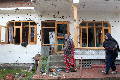 Women enter their bullet ridden house which was damaged during an encounter between security men and Lashkar-e-Toiba (LeT) militants at Ahmed Nagar Soura, Srinagar on Monday. PTI Photo