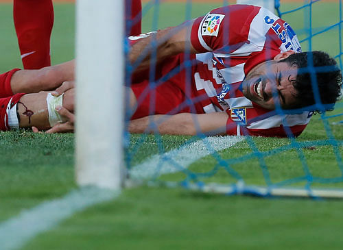 big blow: Diego Costa of Atletico Madrid writhes in pain after seriously injuring his shin during their La Liga match against Getafe on Sunday. AP photo