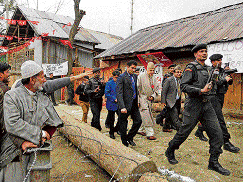 flanked by security: National Conference leader Farooq Abdullah (centre right in a long robe) arrives at an election rally in Rawalpora village, Srinagar, on Tuesday. AP