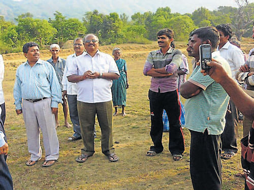 Zilla Panchayat Chief Executive Officer Karunakar interacts with the villagers of Addagudde in Oorubage gram panchayat in Mudigere taluk on Wednesday. The villagers who had announced of boycotting the election have withdrawn their decision. DH Photo