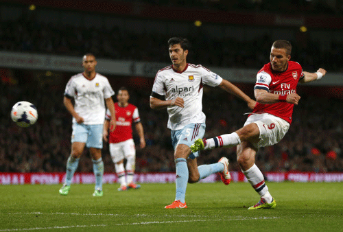 Arsenal's Lukas Podolski  scores his second goal against West Ham United during their English Premier League soccer match at the Emirates stadium in London. Reuters photo