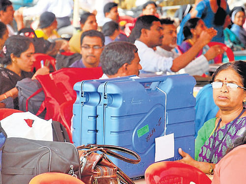 Polling officials collecting Electronic Voting Machines at a mustering centre in Mysore. DH Photo