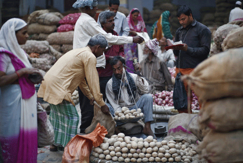 A vendor weighs potatoes for a customer at a vegetable wholesale market along a roadside in the old quarters of Delhi. Markets on Wednesday lost their way in the post-noon session due to caution surrounding FII outflows and higher-than-expected inflation data released on Tuesday. Reuters photo
