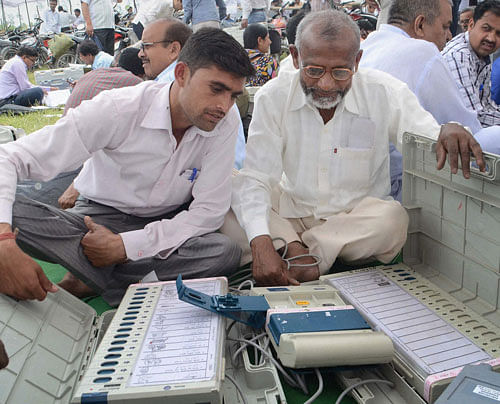 Polling officials check Electronic Voting Machines (EVM's) at a distribution centre on the eve of Lok Sabha polls on Wednesday. Early morning voters, including many senior citizens, were bewildered when an electronic voting machine (EVM) reportedly ''transferred'' all votes to the Congress. PTI Photo