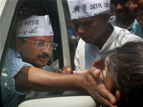 AAP convener Arvind Kejriwal meets a girl in a Varanasi slum aera(Malin basti). PTI Image