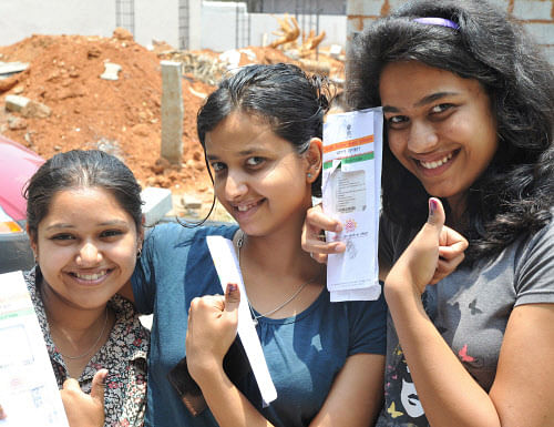 First time voters Bhuvana, Meghana and Maithri shows their voter ID card and their inked thumb after casting their vote in Bangalore on Thursday. Photo Srikanta Sharma R.