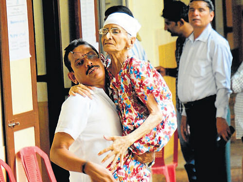 85-year-old Jeni Bai being carried by her kin after exercising her franchise at SDM College in&#8200;Mangalore. DH Photo