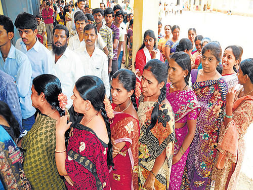 A large number of people wait to cast their votes at Nammura Sarkari Model Primary School at Hoodi in the City on Thursday. DH Photo