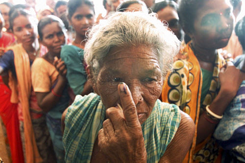 An old voter shows her inked finger after casting vote for Lok Sabha elections at a village in Khurda on Thursday. PTI Photo