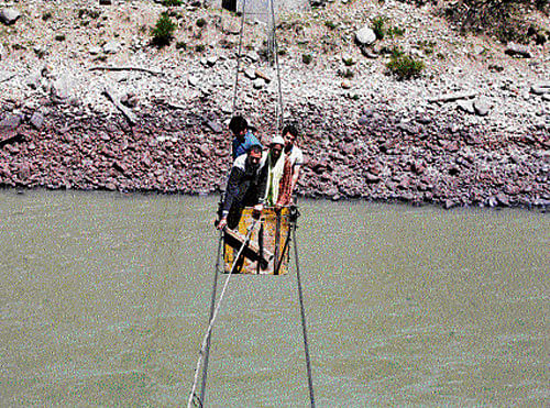 People cross the Chenab river on a trolley tied to wires to cast their vote at Harshi village in Doda district, north of Jammu, on Thursday. REUTERS