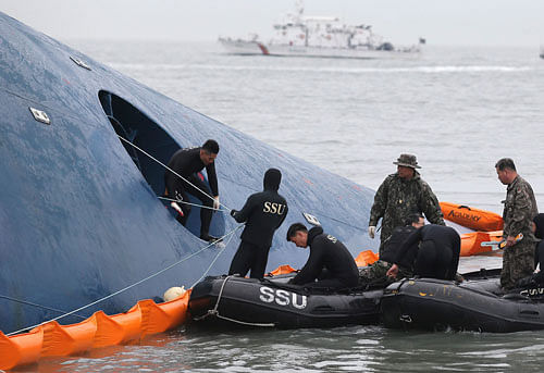 Members of South Korean Ship Salvage Unit (SSU) search for passengers who were on the South Korea ferry 'Sewol' which sank in the sea off Jindo April 17, 2014. South Korean coastguard and navy divers resumed searching on Thursday for about 290 people still missing, many of them students from the same high school, after the ferry capsized in sight of land. REUTERS