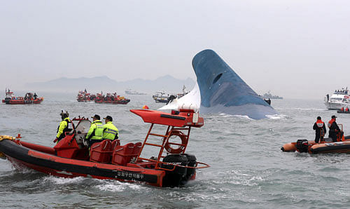 South Korean coast guard officers and rescue team members try to rescue passengers from the ferry Sewol in the water off the southern coast near Jindo, south of Seoul, Wednesday, April 16, 2014. Dozens of boats, helicopters and divers scrambled Wednesday to rescue more than 470 people, including 325 high school students on a school trip, after a ferry sank off South Korea's southern coast. AP