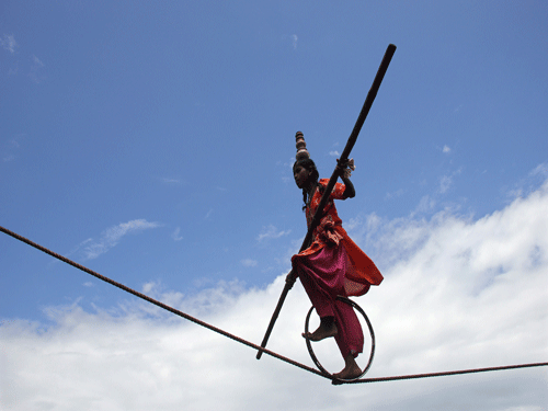A tightrope walker performs on a rope while holding a balancing pole during a performance at Puri. Reuters photo