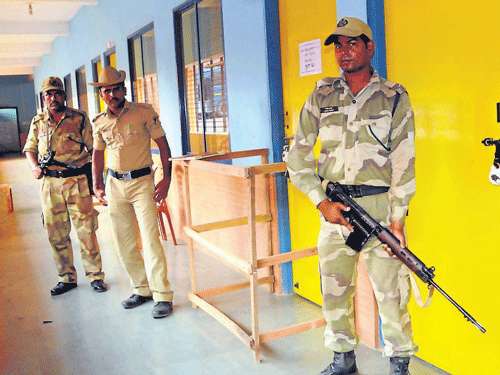 CISF and police personnel guard the strong room at Mahatma Gandhi Centenary Composite P U College of Commerce and Management in which the                      Electronic Voting Machines have been kept after the poll, at Bondel in Mangalore on Friday. DHNS