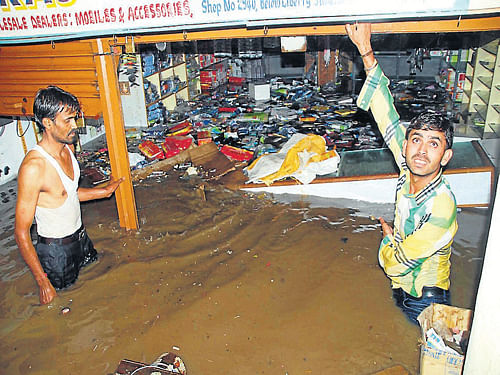 Shops in Kasturba road, in Hassan were inundated following heavy downpour, on Friday. DH Photo