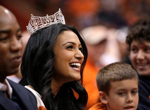 In this Saturday, Feb. 15, 2014, file photo, Miss America 2014 Nina Davuluri attends the NCAA college basketball game between Syracuse and North Carolina State in Syracuse, N.Y. A Pennsylvania high school student is in hot water for asking Davuluri to prom during a question and answer session at school. Eighteen-year-old Patrick Farves said he received three days of in-school suspension Thursday, April 17, 2014, because he asked Davuluri to prom. School officials heard about Farves' plan in advance and warned him not to do it. He has apologized for disrupting the event. AP