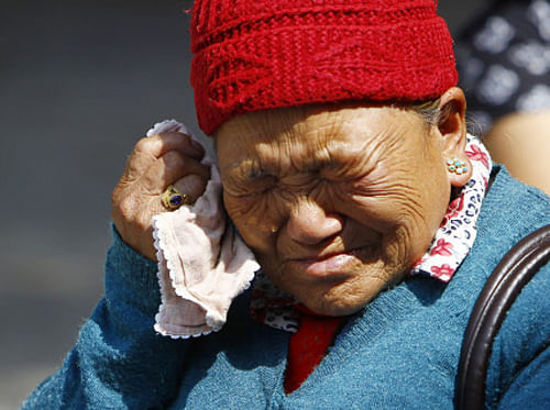 Mother of Nepalese mountaineer Ang Kaji Sherpa, killed in an avalanche on Mount Everest, cries while she waits for his body at Sherpa Monastery in Katmandu, Nepal, Saturday, April 19, 2014. Rescuers were searching through piles of snow and ice on the slopes of Mount Everest on Saturday for four Sherpa guides who were buried by an avalanche that killed 12 other Nepalese guides in the deadliest disaster on the world's highest peak. The Sherpa people are one of the main ethnic groups in Nepal's alpine region, and many make their living as climbing guides on Everest and other Himalayan peaks. (AP Photo/Niranjan Shrestha)