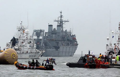 Divers today retrieved the first bodies from the submerged South Korean ferry that capsized nearly four days ago, marking a grim new stage in the search and recovery process. AP photo