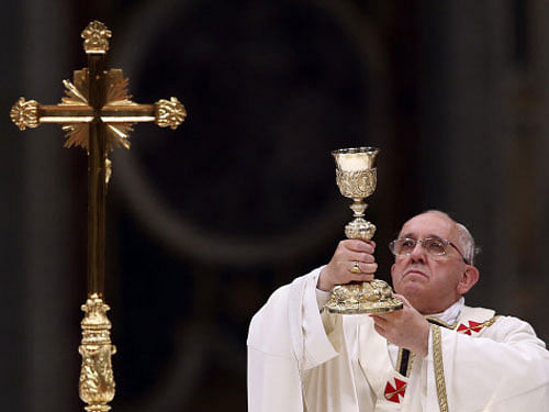 Pope Francis lifts up the chalice as he leads a vigil mass during Easter celebrations at St. Peter's Basilica in the Vatican April 19, 2014. REUTERS
