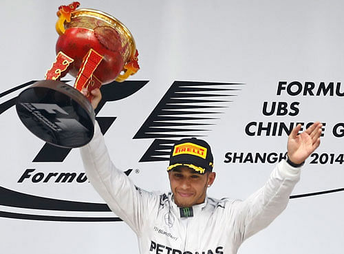First-placed Mercedes Formula One driver Lewis Hamilton of Britain (C) celebrates with his trophy at the podium, after the Chinese F1 Grand Prix at the Shanghai International circuit, April 20, 2014. REUTERS