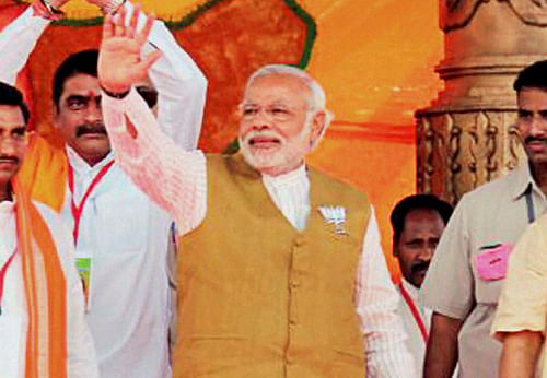 Bilaspur: BJP's Prime Ministerial candidate Narendra Modi waves to the supporter at a rally in Bilaspur, Chhattisgarh on Sunday. PTI Photo