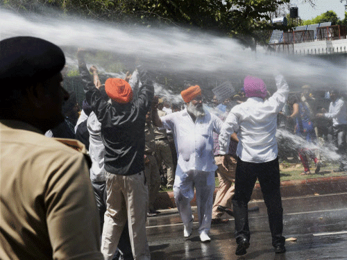 Police use water cannons to disperse sikh protesters during a protest against Congress leaders in New Delhi on Monday. PTI Photo