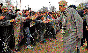 NC leader Farooq Abdullah shakes hand with his supporters at a rally on the outskirts of Srinagar. AP