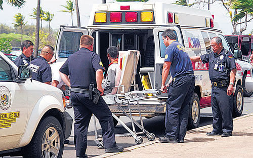Medical personnel load the 16-year-old boy onto an ambulance at Kahului Airport, Hawaii, on Sunday. AP