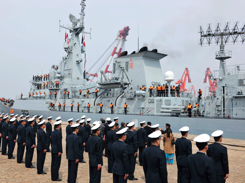 Chinese navy officers (backs to camera) stand in formation as Pakistan naval frigate Shamsher arrives at a military port before a maritime drill. REUTERS photo