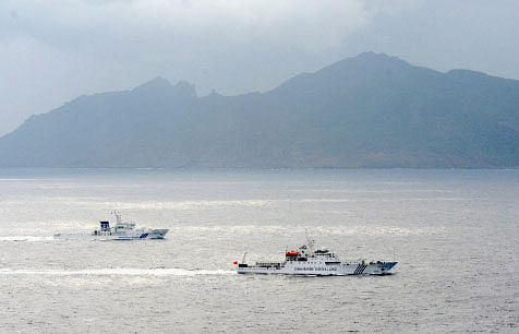 FILE - In this April 23, 2013 file photo, a Japan Coast Guard vessel, left, sails along with a Chinese surveillance ship near the disputed islands called Senkaku in Japan and Diaoyu in China in the East China Sea. AP photo