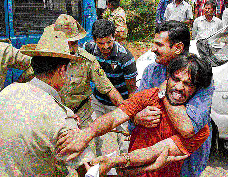 Police arrest one of the protesters who gatecrashed into the Bangalore University Syndicate meeting on Friday. DH Photo