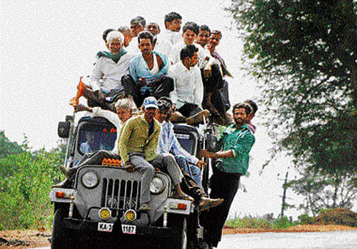 The front and rear view of passengers occupying every bit of the space available on a jeep as they travel through Honnali village in Kalaghatagi taluk of Dharwad district on Friday. While this common practice on the roads is a feast for the shutterbugs, it raises questions as to why the authorities fail to check overloading of vehicles, that frequently causes accidents. DH photo