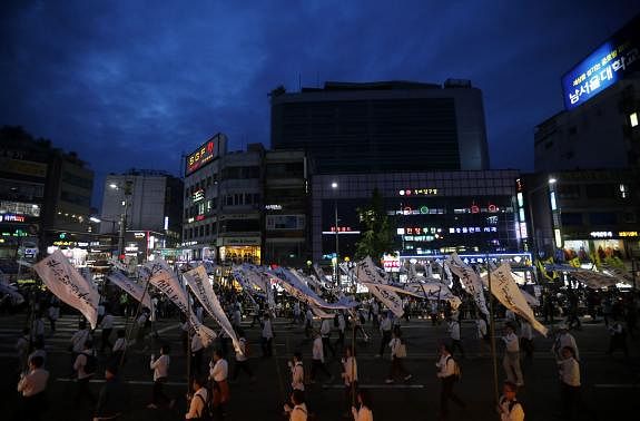 Participants holding funeral streamers bearing messages for victims of the capsized passenger ship Sewol, march during a lotus lantern parade to celebrate the upcoming birthday of Buddha and to commemorate the victims, in Seoul April 26, 2014. Reuters