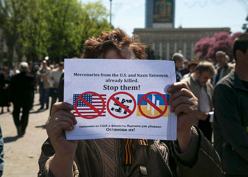 A pro-Russian activist holds a sign during a rally in Donetsk, Eastern Ukraine, April 27, 2014. U.S. President Barack Obama on Sunday said the United States and Europe must join forces to impose sanctions on Russia to stop it destabilising Ukraine, where armed pro-Russian separatists were for a third day holding eight international observers prisoner. REUTERS