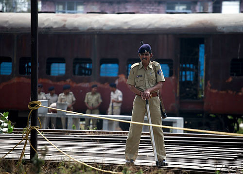 A policeman stands guard near a train carriage, that was set on fire in 2002, during the commemoration of the 12th anniversary of Godhra riots at Godhra on February 27, 2014. The riots were some of the country's worst religious riots since independence, killing some 2,500 people, mainly Muslims. REUTERS