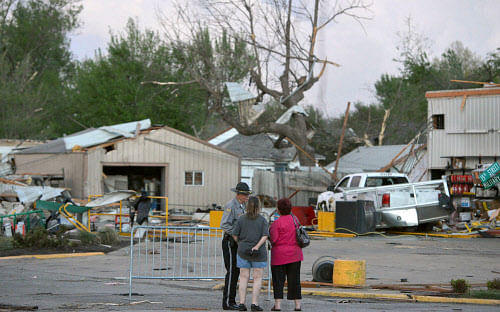 A officer talks to people at 15th and Military following Sunday's tornado in Baxter Springs, Kan., Sunday April 27, 2014. A powerful storm system rumbled through the central and southern United States on Sunday, spawning a massive tornado that carved through Little Rock's northern suburbs and another that hit Oklahoma and Kansas. AP Photo