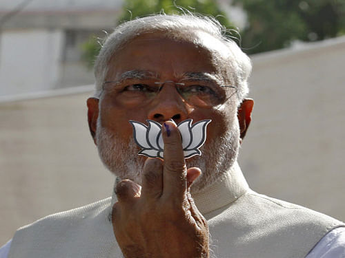 Narendra Modi today landed in a controversy when he displayed his party symbol 'Lotus' and addressed the media after casting his vote, with the Congress moving the EC against the move and demanding that the poll body file an FIR against him. Reuters photo
