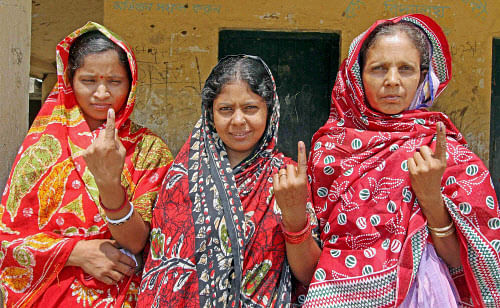 Women show their ink marked fingers after casting their votes for Lok Sabha elections at a polling station in Birbhum district of West Bengal on Wednesday. PTI Photo