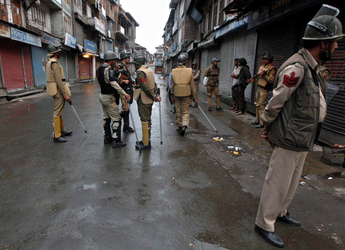 Policemen stand guard along a deserted street during a protest strike in Srinagar April 30, 2014. Police fired teargas in Kashmir region on Wednesday to break up small groups of young men protesting against a general election as voters largely stayed away from polling stations in the troubled valley. REUTERS