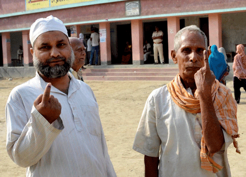 A Muslim and a Hindu voter show their inked fingers at a polling station in Samastipur on Wednesday. PTI Photo